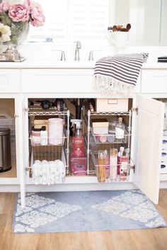 an organized bathroom cabinet in the middle of a wooden flooring area with pink flowers