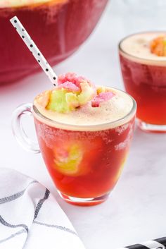 two glasses filled with drinks sitting on top of a white table next to each other