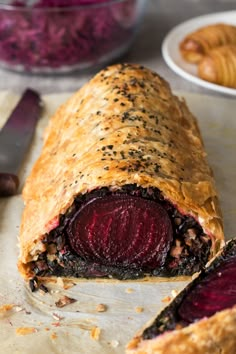 a close up of a pastry with beets in the middle and other pastries