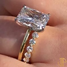 a close up of a person holding a ring with a large diamond on the side