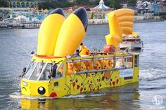 a yellow boat with lots of decorations on it's side in the water next to a pier