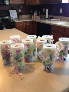 several plastic cups are sitting on the kitchen counter with ribbons around them and tags attached to them