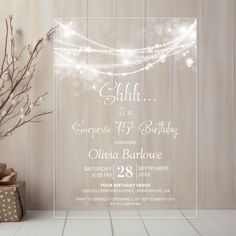 an elegant birthday party with presents and lights on the table in front of a wooden wall