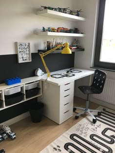 a room with a desk, chair and shelves on the wall next to a window