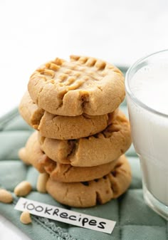 a stack of cookies next to a glass of milk on a blue cloth with a note that reads, tookecies