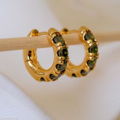 Enhance your jewelry collection with our Minimalist Peridot Hoop Earrings. Featuring a striking dark green peridot set in chunky gold huggie hoops, these earrings blend simplicity with bold elegance. Perfect for everyday wear, these huggie earrings offer a touch of sophistication and are an ideal gift for her. Whether for a special occasion or to elevate daily outfits, these gold huggie earrings with beautiful peridot gemstones are sure to impress and become a cherished accessory. DETAILED DESCR Dark Green Earrings, Gold Huggie Earrings, Huggie Earrings Gold, Chunky Hoop Earrings, Peridot Earrings, Rose Quartz Earrings, Peridot Gemstone, Green Peridot, Huggie Earrings