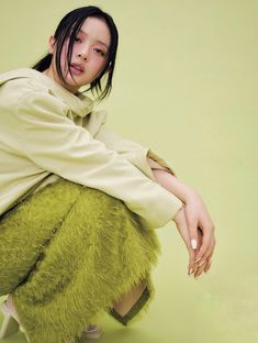 a woman sitting on top of a green chair