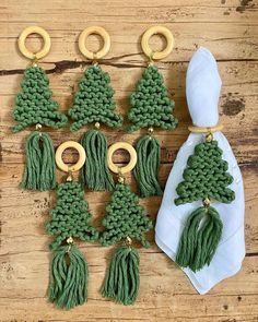 green crocheted christmas tree ornaments with gold rings and hooks on a wooden surface