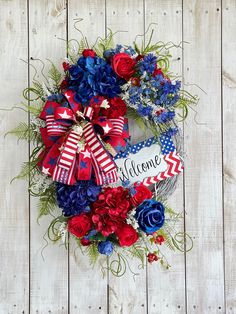 a patriotic wreath with the word welcome on it and red, white, and blue flowers