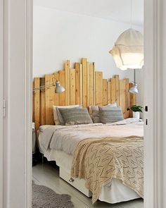 a bed sitting in a bedroom next to a wooden headboard on top of a wall