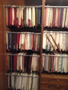 a closet filled with lots of different types of fabric on shelves next to a dresser