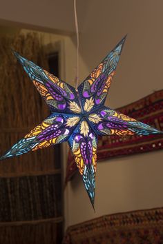 an ornament shaped like a star hanging from a ceiling