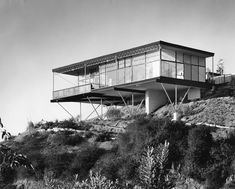 a black and white photo of a house on top of a hill