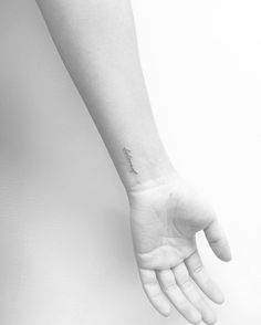 a person's hand with a small tattoo on the wrist and an armband