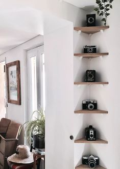 a living room filled with furniture and lots of shelves next to a wall mounted camera