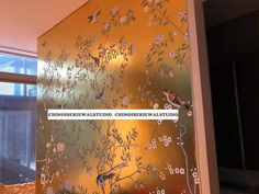 the wall is decorated with flowers and birds in gold, silver or pink colors as well as black lettering