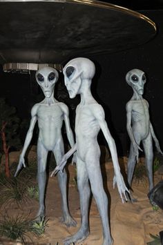 three alien statues standing next to each other