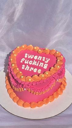 a pink and orange heart shaped cake with the words always be happy on it's side