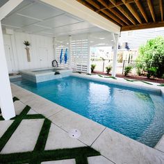 an indoor swimming pool with artificial grass on the floor and in between two pavilions