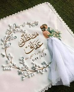 an embroidered wedding handkerchief with a bride and groom's name in arabic on it