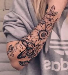 a woman's arm with flowers and butterflies on it