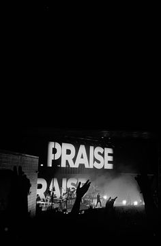 a group of people standing on top of a stage with their hands in the air