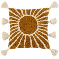 a brown and white pillow with tassels on it