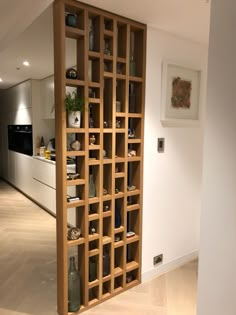 an open bookcase in the middle of a room with white walls and wood flooring