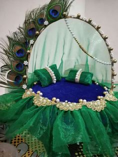 a peacock costume is displayed in front of a mirror with beads and pearls on it