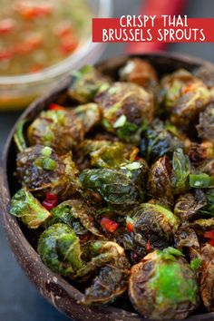 a wooden bowl filled with brussel sprouts on top of a table