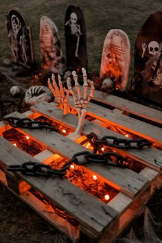 halloween decorations made out of pallets with candles and fake skeleton heads on the ground