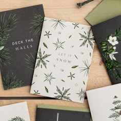 four christmas cards with evergreen leaves and snowflakes on them, one is for deck the hall's let it snow