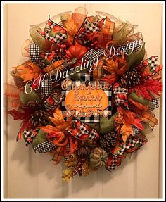 a fall wreath with an orange pumpkin and black checkered ribbon