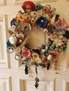 a close up of a wreath on a door with buttons and other items attached to it