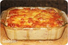 a casserole dish with meat and cheese in it sitting on a wooden table