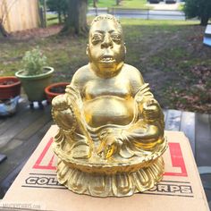 a golden buddha statue sitting on top of a box