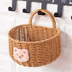 a basket hanging on the wall with a small pig face in it's pocket