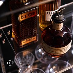 two bottles of liquor sitting on top of a glass shelf