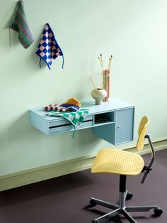 a desk with a yellow chair next to it