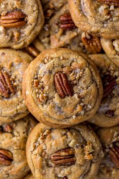 a pile of pecan cookies sitting on top of each other with pecans in the middle