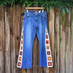 a pair of jeans hanging on a wooden fence