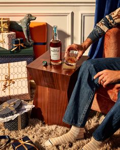 a man sitting in a chair with a bottle of whiskey