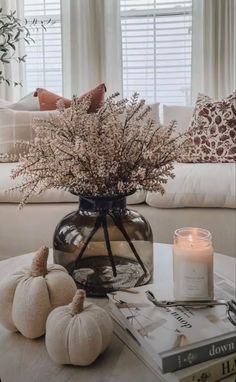 a living room filled with furniture and a table topped with a vase full of flowers