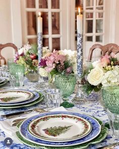 the table is set with plates and candles