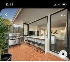 an outdoor kitchen and dining area with sliding glass doors