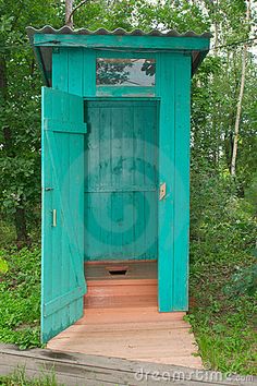 an outhouse in the woods with wooden steps leading up to it's door