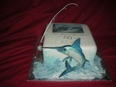 a birthday cake that looks like a dolphin with a fishing hook in it's mouth