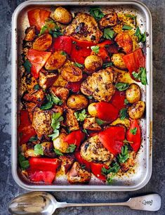 a casserole dish filled with chicken, tomatoes and spinach sprinkled with parsley