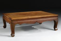 a wooden coffee table sitting on top of a white floor