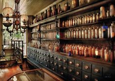 an old fashioned pharmacy cabinet with lots of medicine bottles on the shelves in front of it